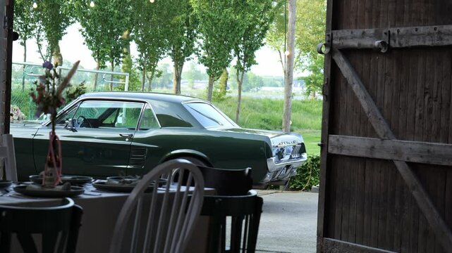 Wedding table setting with decorations, barn door and old car, pan