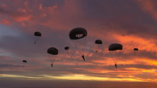 Paratroopers flying during sunrise. Group of people with parachutes fly through an empty environment.