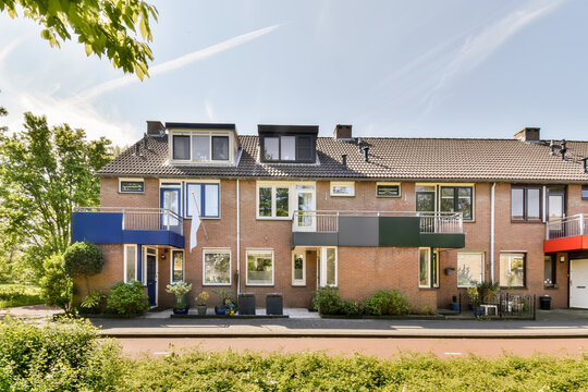 Suburban townhouses with sunny facade and awnings