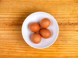 Huevos duros en un bol sobre tabla de madera
