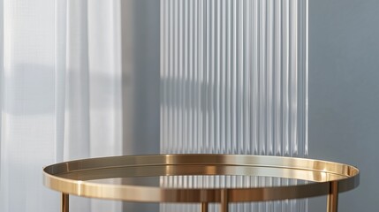 Obraz premium The polished gold surface of a minimalistic tray table shines brightly, set in front of a transparent vertical reeded glass panel. A light gray wall adds depth and neutrality, allowing the product's