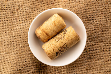 Two wine corks on a jute cloth, macro, top view.