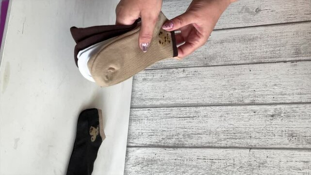 A woman is reviewing a set of socks in different colors. Purchase review. Close up. Vertical video.