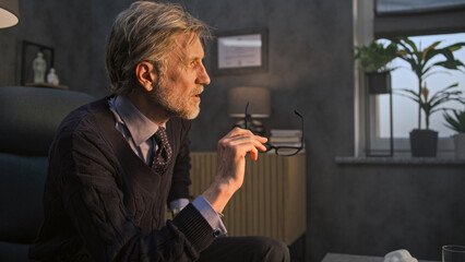 Mature therapist in glasses talks to depressed patient, provides behavior therapy in modern and...