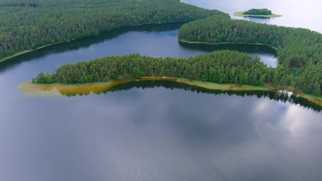 Scenic aerial rotating view of Sciuro Ragas peninsula, separating White Lakajai and Black Lakajai lakes. Picturesque landscape of Labanoras Regional Park. Natural beauty of Lithuania.