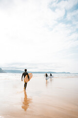    Surfers catching waves, waiting for a wave to come in the middle of the ocean near the beach during a beautiful day