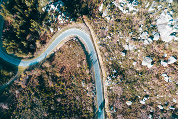 a car driving on a winding mountain road, aerial view with drone