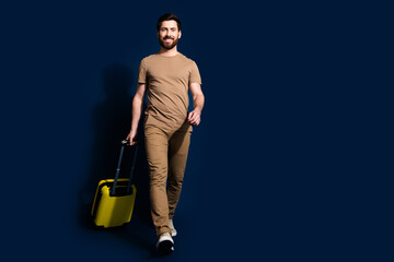 Photo portrait of mature age positive smiling man in beige t shirt flight going with baggage isolated on dark blue color background