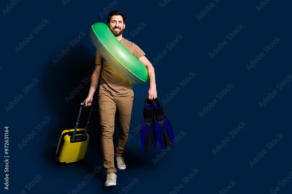 Canvas Prints photo of mature age brunet bearded funny man in beige t shirt bring valise and inflatable ring flipp