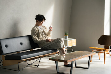 インダストリアルな部屋でスマホを見る若い男性