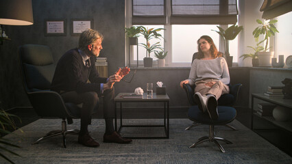 Upset and stressed woman discusses psychological trauma with therapist during counseling session. Mature psychologist talks to female patient, asks questions, provides psychotherapy. Mental health.