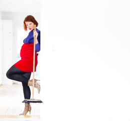 Mother with red hair and make up cleaning a house with broomstick, fat pouch belly, white copy space