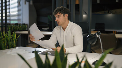 Caucasian busy concentrated business man work in office guy businessman male working paperwork check documents financial stats data papers read managing income company corporate budget financial job
