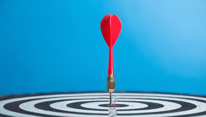 Arrow at darts target, pastel blue backdrop. Business and achieving goals concept.