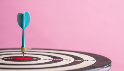 Fototapeta premium Arrow at darts target, pastel pink backdrop. Business and achieving goals concept.