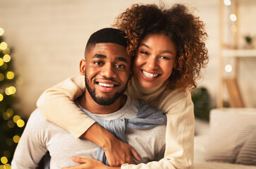 Obraz premium Christmas eve. Loving couple embracing and smiling to camera in front of Christmas tree