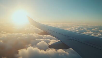 Airplane wing with the sun shining through the clouds.