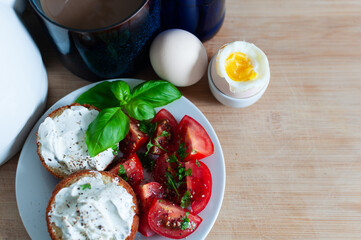 Healthy Breakfast tomato salad, muffins with cream cheese, coffee and hardboiled egg