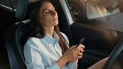 Caucasian woman girl lady driver businesswoman sitting inside car automobile at parking lot browsing smartphone stress worried mobile phone bad news thinking sad unhappy upset anxiety failure problem