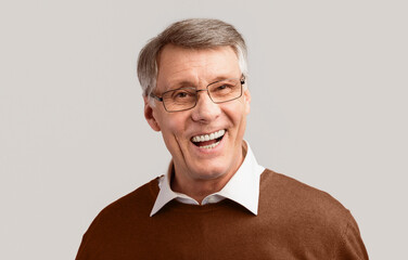 Happy Senior Man Laughing Looking At Camera Posing On Gray Studio Background. Sense Of Humor Concept