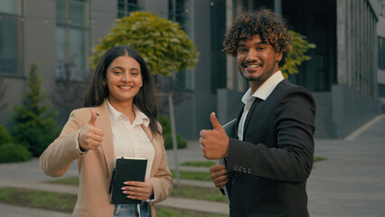 Indian businessman and Arabian businesswoman business partners colleagues people smiling looking at...