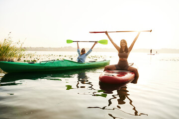 Active weekend, on the water. Women friends are on sup board on the lake together
