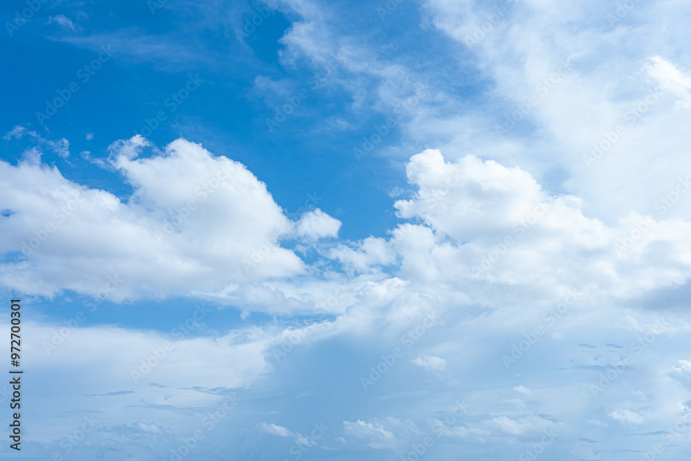 Wall mural beautiful fluffy white clouds drift across a bright blue sky