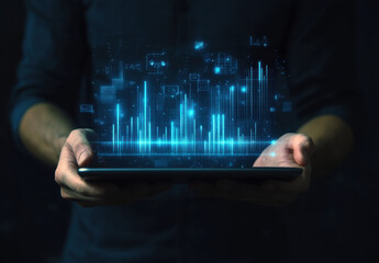 Businessman holding a tablet with a virtual, digital, glowing data chart and bar graph depicting business growth, a social media marketing concept on a black background.