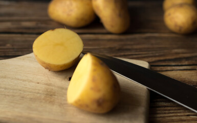 young raw potato. on a dark wooden background. food