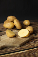 young raw potato. on a dark wooden background. food