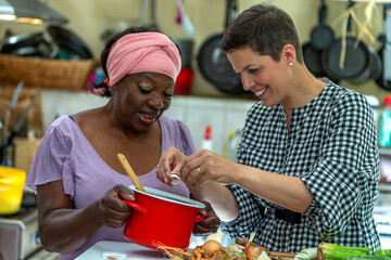 Cooking - womans hands preparing chicken stock broth or bouillon with vegetables in a pot. Kitchen - scenery