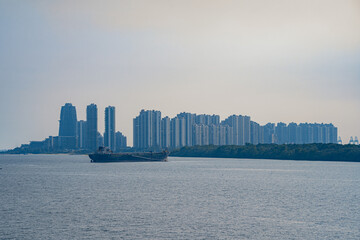 Tuas Second Link Bridge connecting Singapore and Johor, Malaysia. Buildings at Forest City and Singapore's port. View from the Straits of Johor.