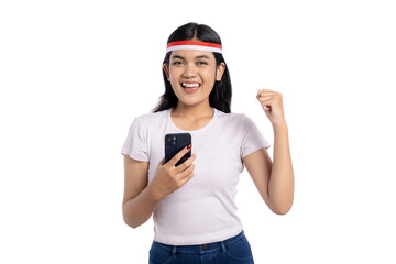 Excited young Asian woman using smartphone, celebrating success isolated on white background. Indonesian Independence Day Celebration Concept