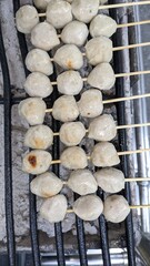 meatballs that are skewered on charcoal stove with grille on street food shop