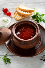 Red ukrainian polish bettroot meat soup in ceramic pot borscht