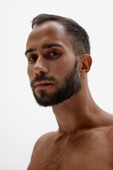 Obraz premium Close up photo of bearded man with thoughtful expression looking at camera against white background. Concept of beauty and fashion, style and youth, male health. Ad.