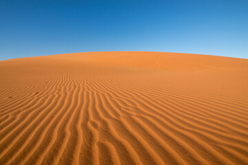 Wind-blown sand lines on a red sand dune in the Deadvlei desert of Namibia