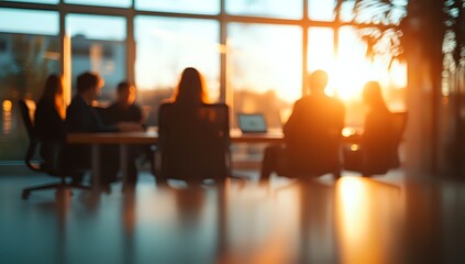 Silhouettes of people in a meeting room with a sunset view.