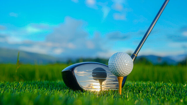 Golf clubs and balls on a green lawn in a beautiful golf course with morning sunshine.