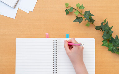 Girl writing in a notebook. Class, classroom, desk, study, learning, homework, preparation, review,...