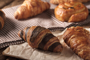 Freshly baked Chocolate Croissant. Arranged on a cloth and parchment paper.