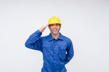 A smiling worker in a yellow hard hat and blue coveralls gives a salute, symbolizing respect, discipline, and dedication.Construction, engineering, maritime, and safety inspection careers.