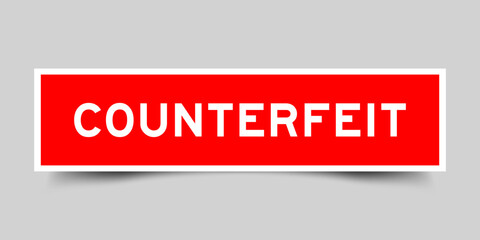 Red color square shape sticker label with word counterfeit on gray background
