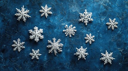 A collection of delicate snowflakes resting on a textured blue background, evoking a sense of icy calm