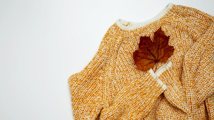 Autumn clothing. Warm golden sweater. Top view. Copy space