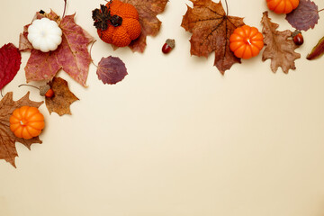 Autumn composition with maple leaves, decorative pumpkins and candles. Top view. Copy space