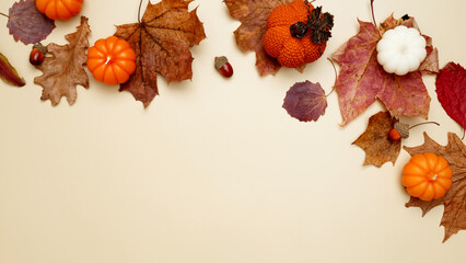 Autumn composition with maple leaves, decorative pumpkins and candles. Top view. Copy space