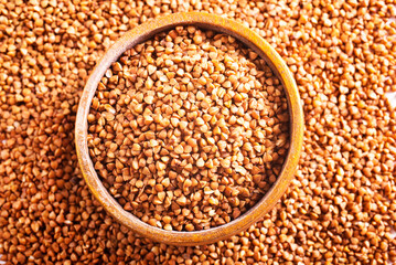 Wooden bowl full of raw wholegrain buckwheat groats