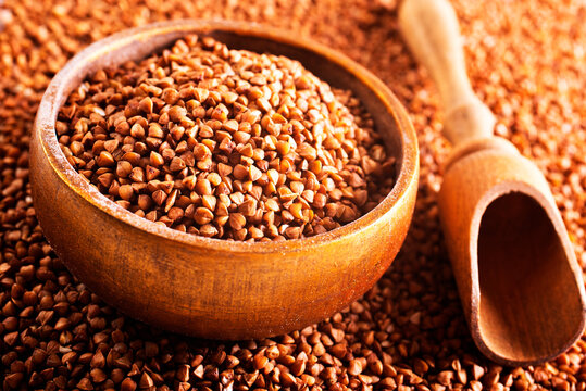 Wooden bowl full of raw wholegrain buckwheat groats