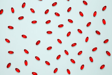 Red pills and capsules scattered. Concept of medicine, healthcare, and pharmaceutical industry